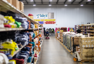 Customer selling an aisle of clothes at warehouse store