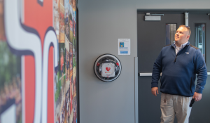 Man looking at team photos on a wall